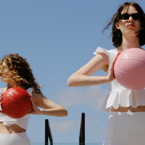Two woman wearing white activewear tops